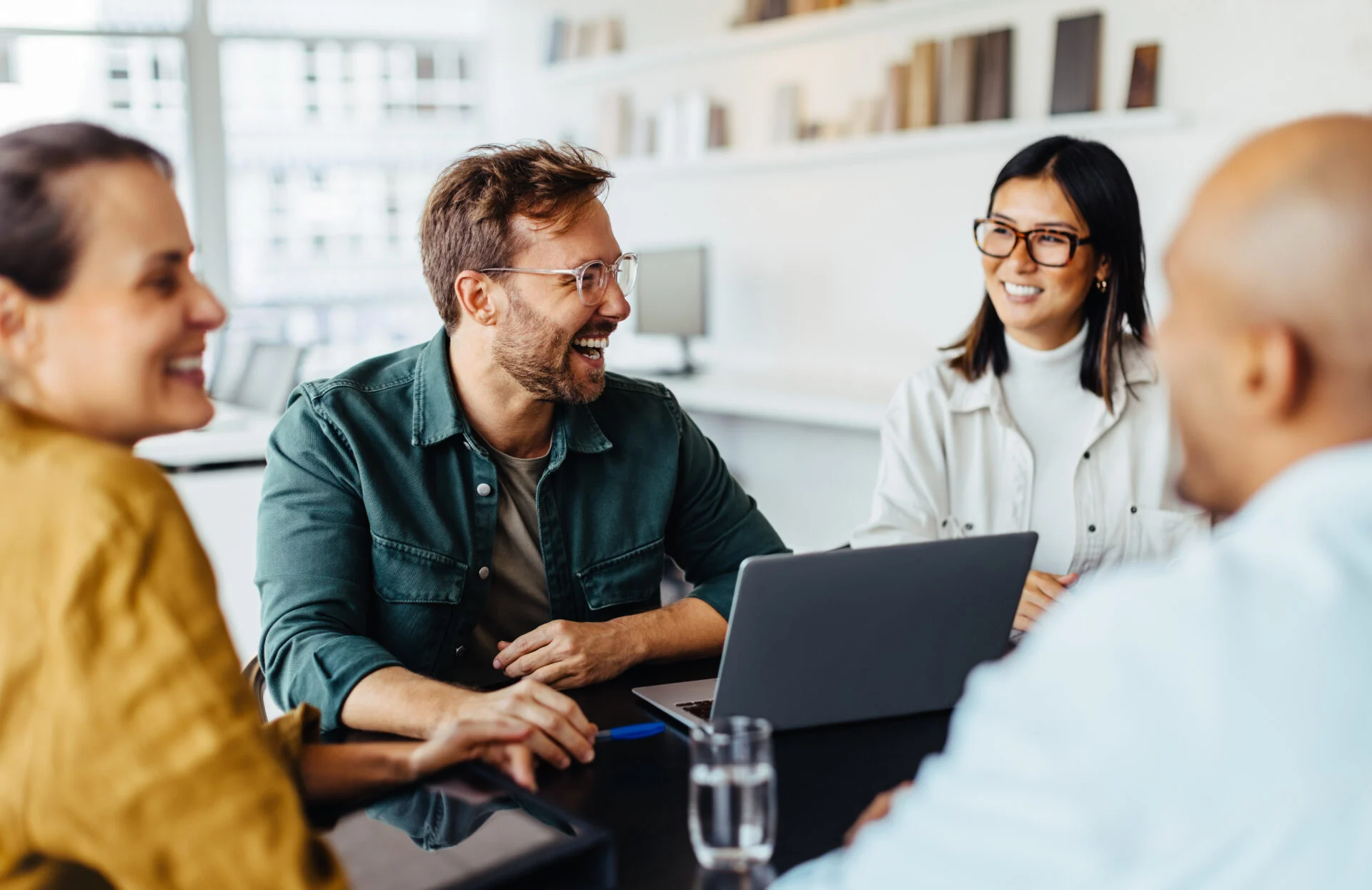 Diverse business people having a team meeting in an office. Group of happy business professionals sitting around a table and having a discussion.